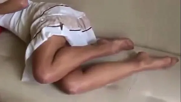 Heiße Schwarzhaariges junges Mädchen im weißen Kleid zeigt ihre Füße in hellbrauner Strumpfhosewarme Filme