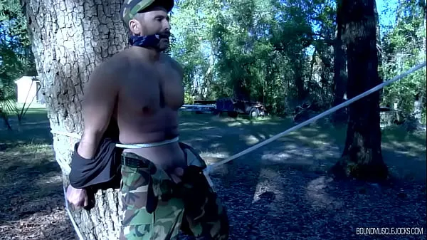 Hotte 2 muscular military men are tied up to the trees outside varme filmer